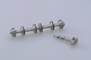 A clinician glides a smooth metal therapy instrument across a patient’s calf muscle on a treatment table.