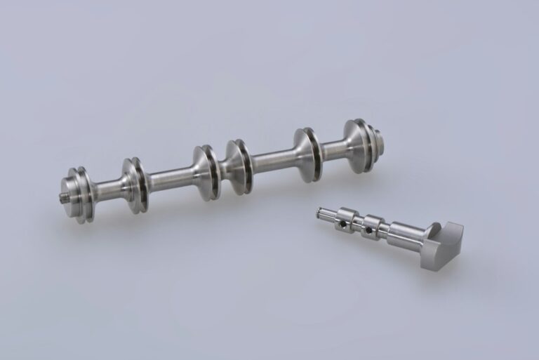 A clinician glides a smooth metal therapy instrument across a patient’s calf muscle on a treatment table.